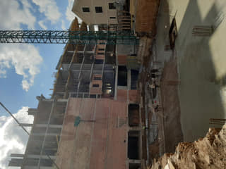 Construction photo of the rising structure beside the tower crane