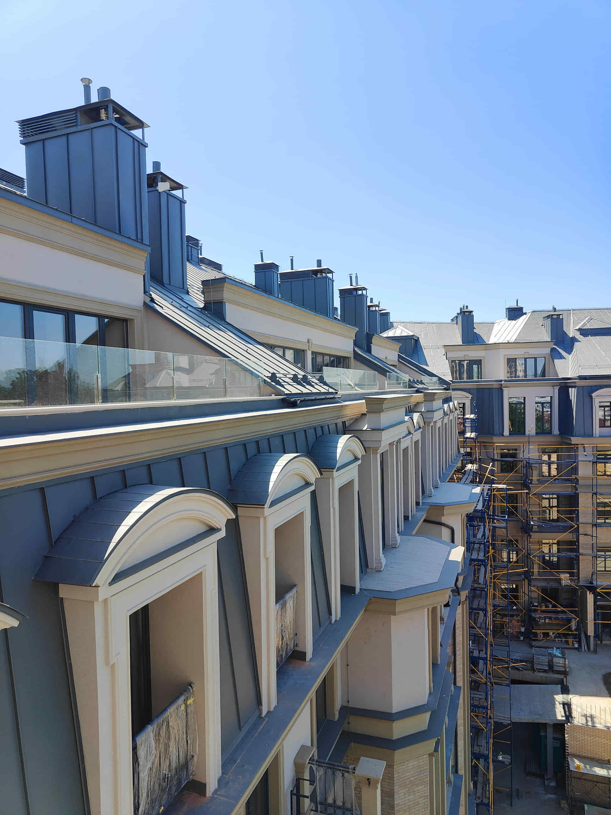 Construction photo along the completed mansard roof and dormers