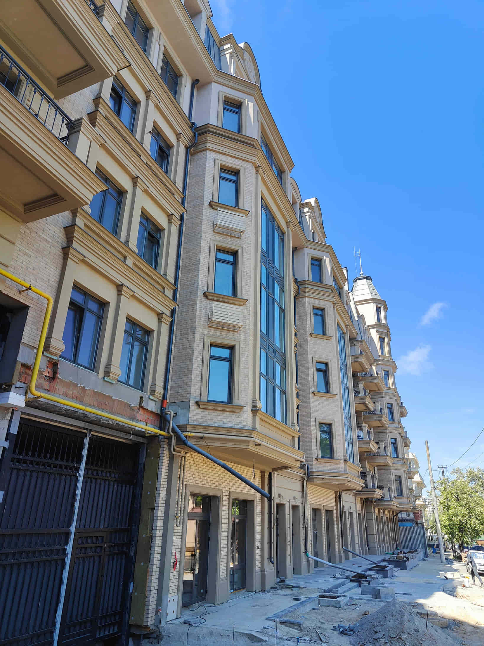Street-level construction photo of the nearly completed facade