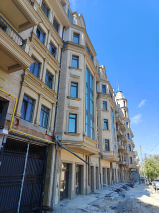 Street-level construction photo of the nearly completed facade